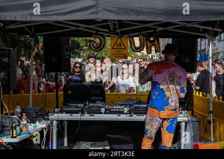 Giovani che ballano di fronte a uno stand di DJ all'aperto al Kallio Block Party 2023 nel quartiere Harju di Helsinki, Finlandia Foto Stock