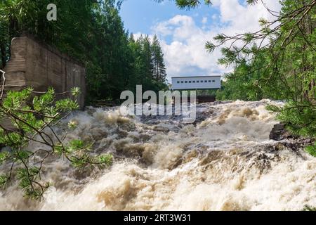 cascata durante le chiuse aperte per lo scarico inattivo dell'acqua in una piccola centrale idroelettrica Foto Stock