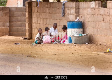 Gaborone, Botswana 6 giugno 2009, editoriale, gruppo di bambini africani che giocano sulla strada sterrata di fronte alla casa vicino al cestino della spazzatura Foto Stock