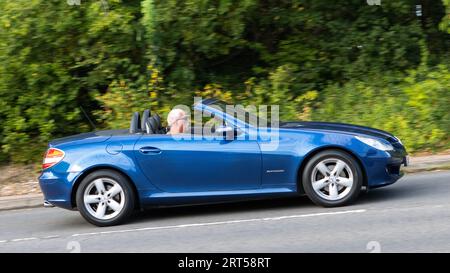 Milton Keynes, UK-10 settembre 2023: 2004 Mercedes Benz SLK 200 blu cabriolet che viaggia su una strada inglese. Foto Stock