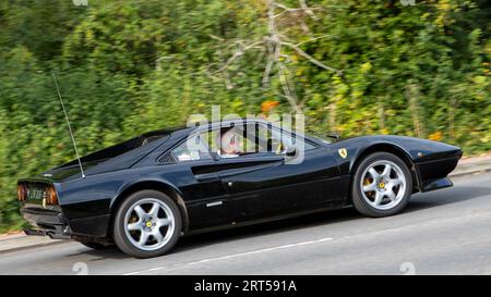 Milton Keynes, Regno Unito-10 settembre 2023: 1976 auto nera Ferrari 308 che viaggia su una strada inglese. Foto Stock
