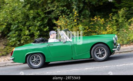 Milton Keynes, UK-10 settembre 2023: 1971 Green MG Midget classica auto sportiva britannica che viaggia su una strada inglese. Foto Stock