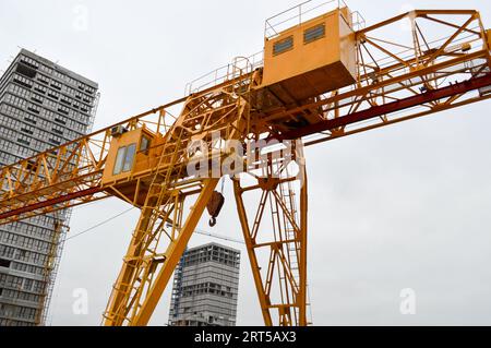 Struttura portante in ferro giallo pesante industriale stazionaria potente gru a portale di tipo a ponte su supporti per il sollevamento del carico su un m Foto Stock