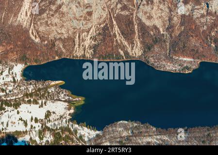 Vista aerea di Ukanc, piccolo insediamento sulla costa occidentale del lago Bohinj durante l'inverno nel parco nazionale sloveno Triglav, famosa destinazione di viaggio Foto Stock