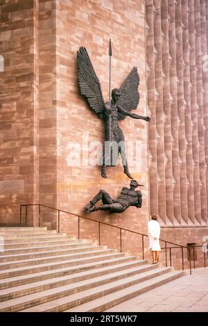 Woman standing looking at sculpture Coventry Cathedral Church, West Midlands, England, UK, marzo 1966 "St Michael's Victory Over the Devil" 1958 Bronze sculpture by Jacob Epstein, Foto Stock