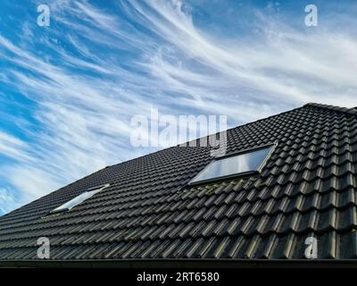 Finestrino aperto sul tetto in stile Velux con tegole nere Foto Stock