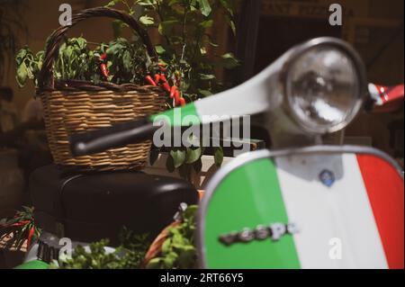 Una Vespa Piaggio con un cesto di peperoncini in mostra a Tropea, Calabria Foto Stock