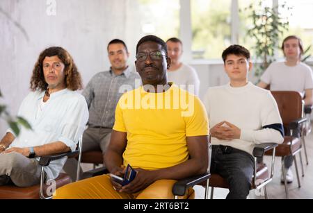 Un uomo afroamericano concentrato che tiene conferenze in auditorium Foto Stock