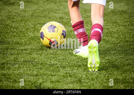 Primo piano dei piedi che giocano a calcio, nei colori del West Ham Foto Stock