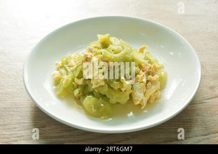 mescolare la fetta di melone amaro fritta con l'uovo in salsa sul piatto Foto Stock