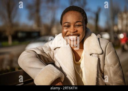 Primo piano all'aperto ritratto di felice afro-americana donna in giornata di sole. Foto Stock