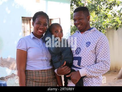 (230911) -- MAPUTO, 11 settembre 2023 (Xinhua) -- Nunes Guardagea, sua moglie e suo figlio posano per una foto di famiglia nel loro cortile a Matola, provincia di Maputo, Mozambico, 28 luglio 2023. Il governo del Mozambico ha annunciato nel maggio 2020 il completamento di un progetto per portare il segnale televisivo digitale satellitare a 1.000 villaggi del paese, che ha beneficiato oltre 20.000 famiglie. Il progetto, che copre tutte le dieci province e la capitale del Mozambico, è stato cofinanziato dalla Cina e implementato dalla società cinese di elettronica e media StarTimes. Ha formato la forza lavoro, in particolare i giovani Foto Stock