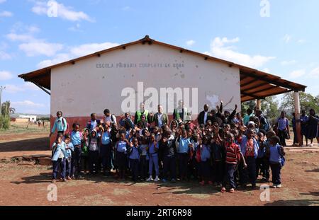 (230911) -- MAPUTO, 11 settembre 2023 (Xinhua) -- Nunes Guardagea e i suoi colleghi posano per una foto di gruppo con insegnanti e studenti in una scuola nel villaggio di Goba, provincia di Maputo, Mozambico, 26 luglio 2023. Il governo del Mozambico ha annunciato nel maggio 2020 il completamento di un progetto per portare il segnale televisivo digitale satellitare a 1.000 villaggi del paese, che ha beneficiato oltre 20.000 famiglie. Il progetto, che copre tutte le dieci province e la capitale del Mozambico, è stato cofinanziato dalla Cina e implementato dalla società cinese di elettronica e media StarTimes. Ha addestrato la forza lavoro Foto Stock