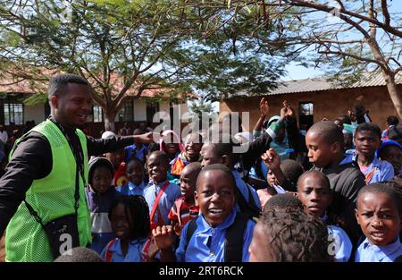 (230911) -- MAPUTO, 11 settembre 2023 (Xinhua) -- Nunes Guardagea interagisce con gli studenti di una scuola del villaggio di Goba, provincia di Maputo, Mozambico, 26 luglio 2023. Il governo del Mozambico ha annunciato nel maggio 2020 il completamento di un progetto per portare il segnale televisivo digitale satellitare a 1.000 villaggi del paese, che ha beneficiato oltre 20.000 famiglie. Il progetto, che copre tutte le dieci province e la capitale del Mozambico, è stato cofinanziato dalla Cina e implementato dalla società cinese di elettronica e media StarTimes. Ha formato la forza lavoro, in particolare i giovani, ad essere responsabile Foto Stock