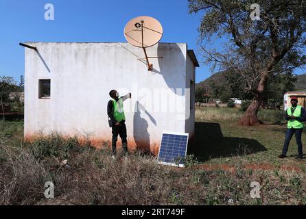 (230911) -- MAPUTO, 11 settembre 2023 (Xinhua) -- Nunes Guardagea (L) e il suo collega controllano l'antenna ricevente della televisione satellitare con aiuti cinesi nel villaggio di Goba, provincia di Maputo, Mozambico, 26 luglio 2023. Il governo del Mozambico ha annunciato nel maggio 2020 il completamento di un progetto per portare il segnale televisivo digitale satellitare a 1.000 villaggi del paese, che ha beneficiato oltre 20.000 famiglie. Il progetto, che copre tutte le dieci province e la capitale del Mozambico, è stato cofinanziato dalla Cina e implementato dalla società cinese di elettronica e media StarTimes. Ha addestrato la forza lavoro Foto Stock