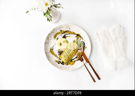 Sfondo romantico con halibut in mantello di zucchine con asparagi e salsa Hollandaise Foto Stock
