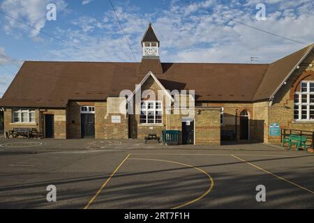 Sharnbrook High Street, Bedfordshire, Inghilterra, Regno Unito, estate - il parco giochi e gli edifici vittoriani della scuola elementare del villaggio di Sharnbrook Foto Stock
