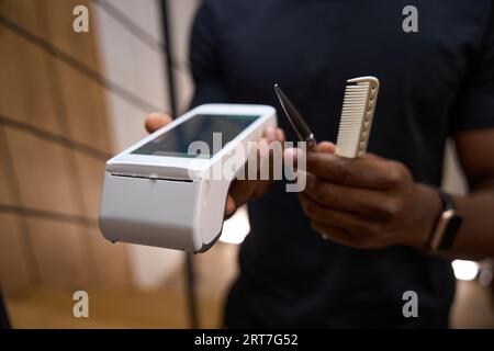 Un maestro afro-americano tiene tra le mani un terminale Foto Stock
