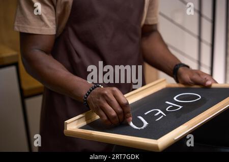 Il giovane scrive in gesso su un segno aperto Foto Stock