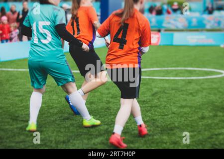 Partita di calcio femminile in strada all'aperto su un prato artificiale di astroerba sintetica, le ragazze giocano a calcio su un campo di campo, le giovani donne partecipano a un calcio Foto Stock