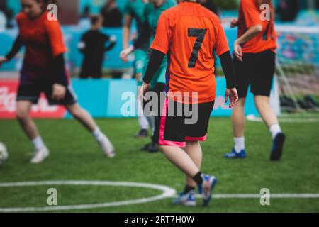 Partita di calcio femminile in strada all'aperto su un prato artificiale di astroerba sintetica, le ragazze giocano a calcio su un campo di campo, le giovani donne partecipano a un calcio Foto Stock