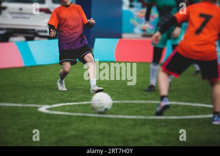 Partita di calcio femminile in strada all'aperto su un prato artificiale di astroerba sintetica, le ragazze giocano a calcio su un campo di campo, le giovani donne partecipano a un calcio Foto Stock