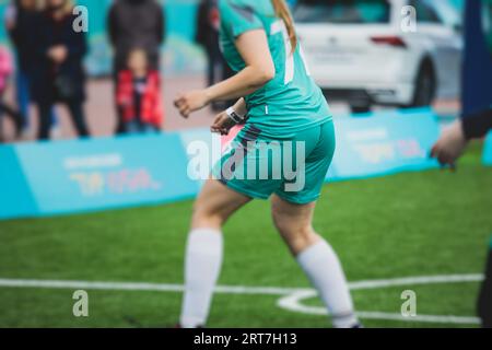 Partita di calcio femminile in strada all'aperto su un prato artificiale di astroerba sintetica, le ragazze giocano a calcio su un campo di campo, le giovani donne partecipano a un calcio Foto Stock