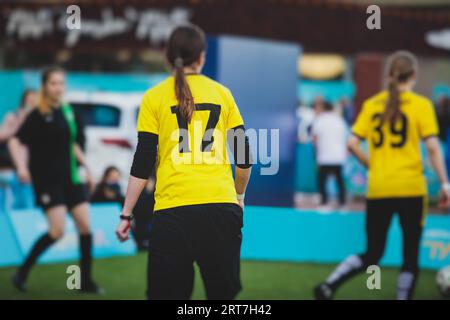 Partita di calcio femminile in strada all'aperto su un prato artificiale di astroerba sintetica, le ragazze giocano a calcio su un campo di campo, le giovani donne partecipano a un calcio Foto Stock