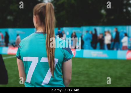 Partita di calcio femminile in strada all'aperto su un prato artificiale di astroerba sintetica, le ragazze giocano a calcio su un campo di campo, le giovani donne partecipano a un calcio Foto Stock