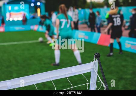 Partita di calcio femminile in strada all'aperto su un prato artificiale di astroerba sintetica, le ragazze giocano a calcio su un campo di campo, le giovani donne partecipano a un calcio Foto Stock