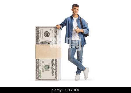 Studente maschio appoggiato su una pila di banconote da dollari e puntato isolato su sfondo bianco Foto Stock