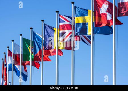 Bandiere di paesi europei su pali che volano nel vento contro il cielo blu Foto Stock