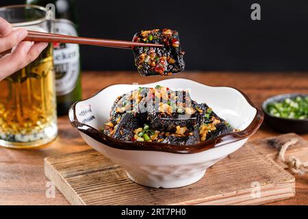 Il tofu stinky è una forma cinese di tofu fermentato che ha un forte odore. Tofu croccante alla Hunan fritto con olio di peperoncino e cipollina. Foto Stock