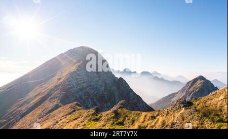 Stunning scene of a mountain ridge, hills, and tops in the morning mist at daybreak, aerial shot. Travel, nature, and environmental conservation Foto Stock