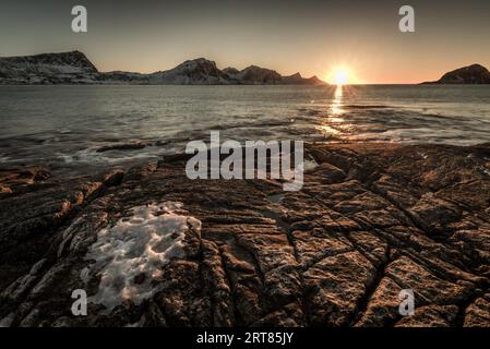 La famosa spiaggia di sabbia nei pressi di Haukland durante il tramonto sul Lofoten isole in Norvegia in chiaro giorno d'inverno con neve-rivestito montagne e cielo blu Foto Stock