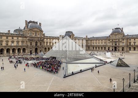 Parigi, Francia, 24 luglio 2017: Gruppi di persone in attesa all'ingresso principale del Museo del Louvre Foto Stock