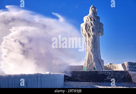 Faro ghiacciato e molo nelle tempeste giornate invernali Foto Stock