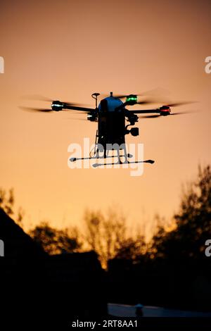 Drone INOVATION con defibrillatore semiautomatico esterno che vola al tramonto Foto Stock