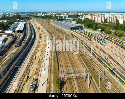 Cracovia, Polonia. Grande hub ferroviario, garage interno e all'aperto con capannoni, treni veloci, carrozze vecchie e nuove, molti binari ferroviari, binari e altri mezzi Foto Stock