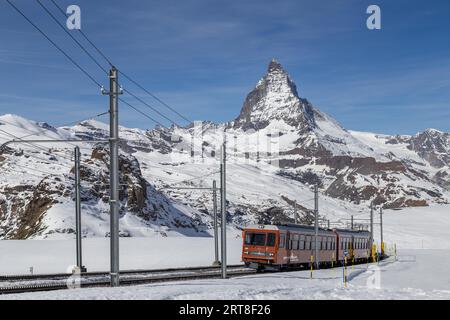 Zermatt, Svizzera, 12 aprile 2017: Il treno rosso Gornergrat davanti alla montagna innevata del Cervino Foto Stock