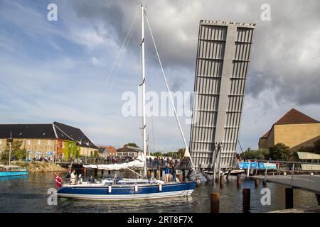 Copenaghen, Danimarca, 2 settembre 2017: Una barca a vela passa attraverso un ponte levatoio aperto nel distretto di Christianshavn Foto Stock