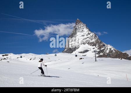 Zermatt, Svizzera, 12 aprile 2017: Una donna che scia davanti al famoso Cervino Foto Stock