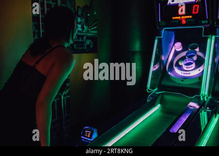 Donna che gioca a ICEBALL, un tradizionale gioco a rulli dei vicoli nella sala giochi Gameworks di Seattle Foto Stock