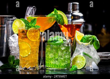 Cocktail alcolici con gin, whisky, vermouth e liquori, sfondo nero bar, atmosfera notturna Foto Stock