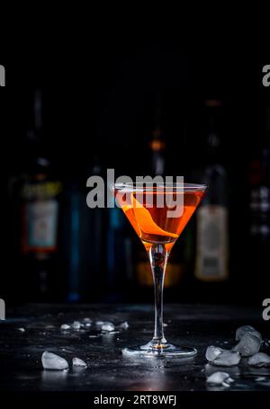 Bobby Burns forte cocktail drink con whisky scotch, vermouth e liquore in un bicchiere di martini, sfondo scuro da bar Foto Stock