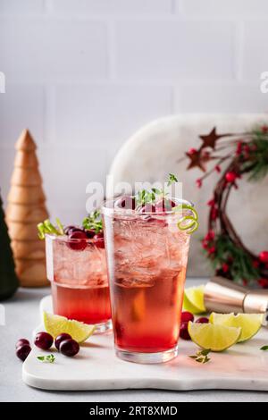 Rinfrescante cocktail di lime ai mirtilli per Natale con scorza di lime e contorno al timo Foto Stock
