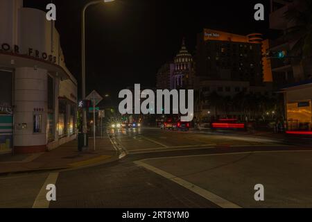 Vista notturna del paesaggio cittadino di Miami Beach con tracciatori di luce sfocati di automobili sulla Collins Avenue. Miami Beach. USA. Foto Stock