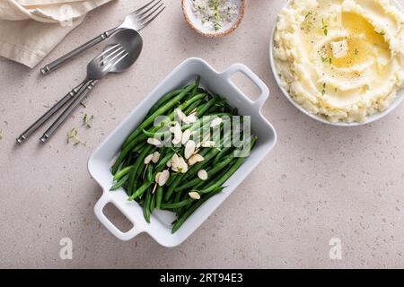 Fagioli verdi conditi con mandorle in un piatto da forno, contorno tradizionale per la cena o la festa di tutti i giorni Foto Stock