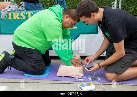 Detroit, Michigan - ad una festa sponsorizzata dal Dipartimento della salute di Detroit, un uomo impara ad aiutare una vittima di arresto cardiaco improvviso usando una C. Foto Stock