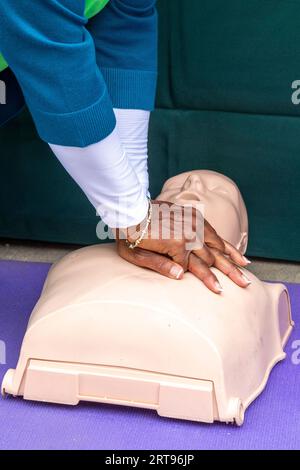 Detroit, Michigan - ad una festa sponsorizzata dal Dipartimento della salute di Detroit, una donna impara ad aiutare una vittima di arresto cardiaco improvviso usando CA Foto Stock